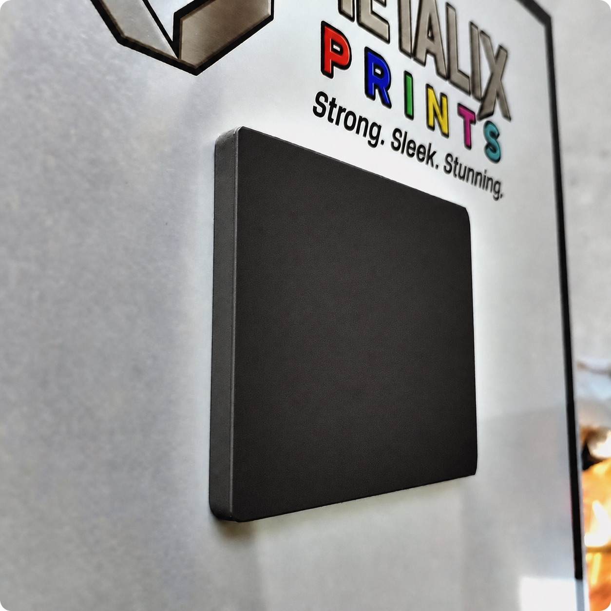 Close-up of the black magnetic mounting pad on the back of a Metalix print