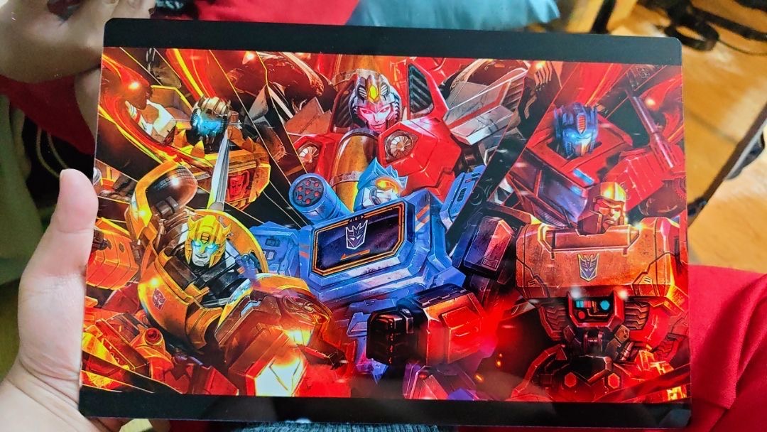 A customer holding a colorful glossy Metalix Transformers print